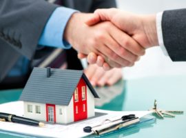 Estate agent shaking hands with customer after contract signature