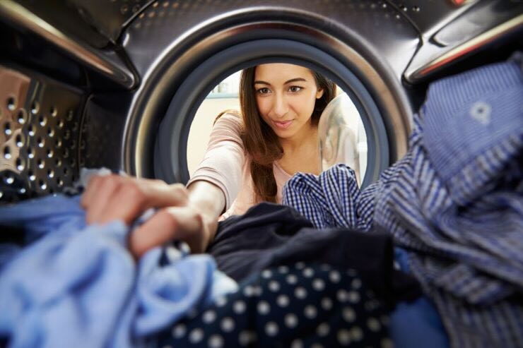 Donna prende vestiti da lavatrice 