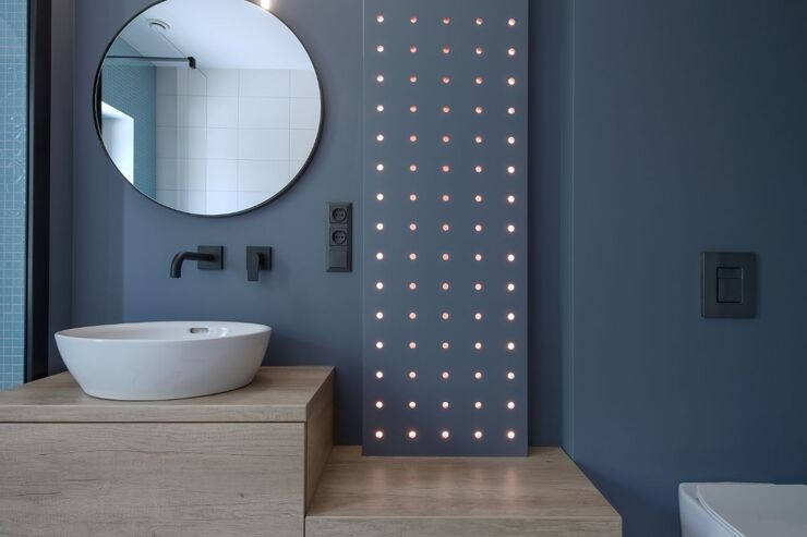 Bagno arredato con specchio, lavabo, luci su parete 