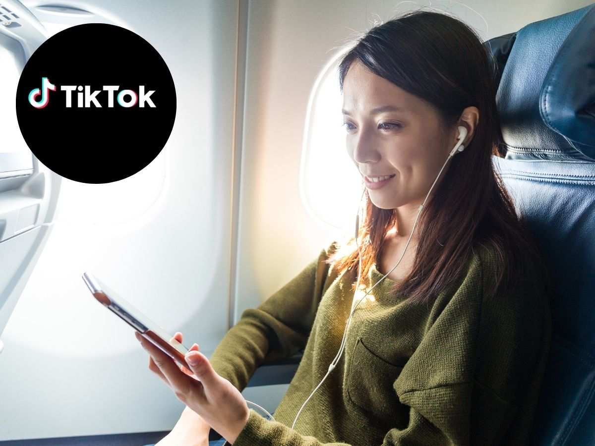 donna con cellulare in mano su aereo e scritta tik tok