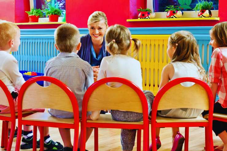 Maestra che parla con i bambini della sua classe d'asilo