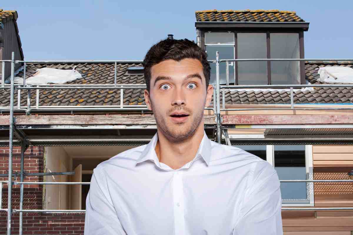 uomo stupito e casa in costruzione