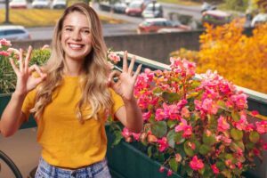 balcone fiori e ragazza gesto ok