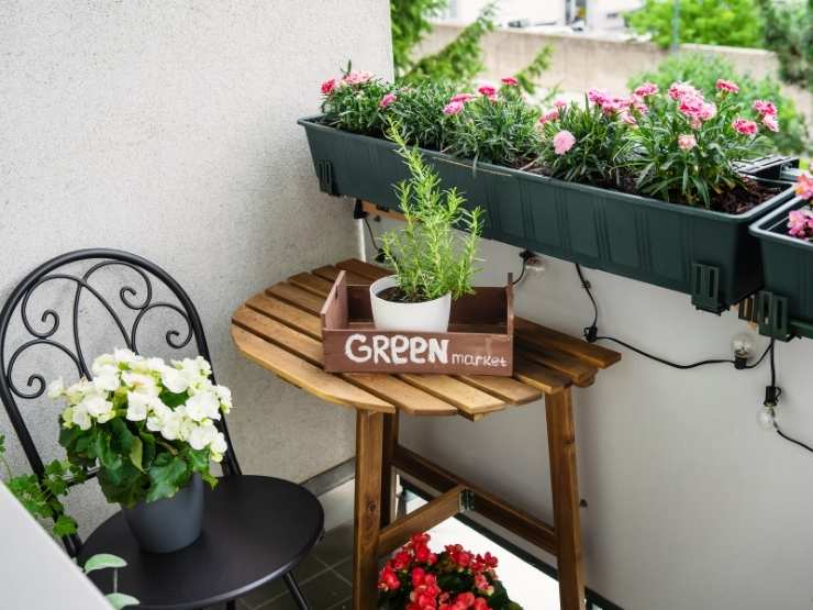 poccolo scorcio di un balcone con fiori e tavolino