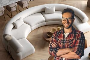 Divano beige, arredo, ragazzo in primo piano sorridente