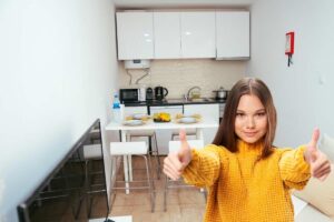 cucina piccola e donna con pollici su