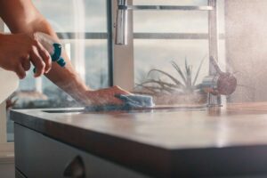 mano che spruzza soluzione su cucina