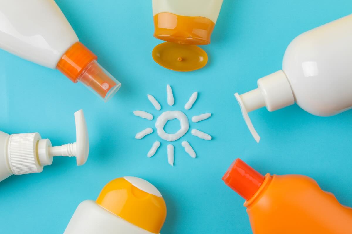 flaconi creme solari e sole disegnato con la crema 
