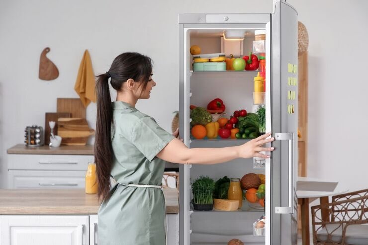 Donna apre sportello frigo 