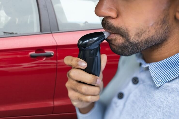 uomo che soffia nell'alcol test