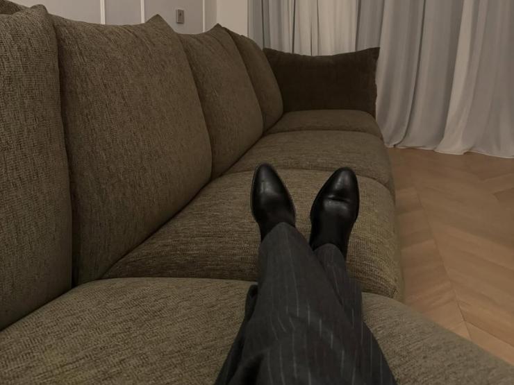 belen sdraiata sul divano mostra gambe e scarpe