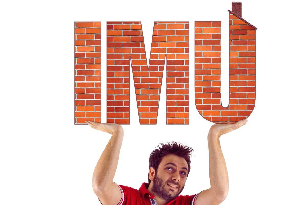 uomo che sorregge scritta di mattoni IMU