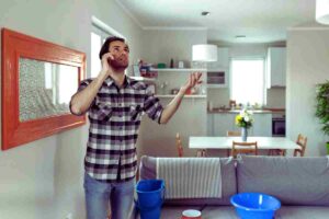 uomo in casa al telefono preoccupato