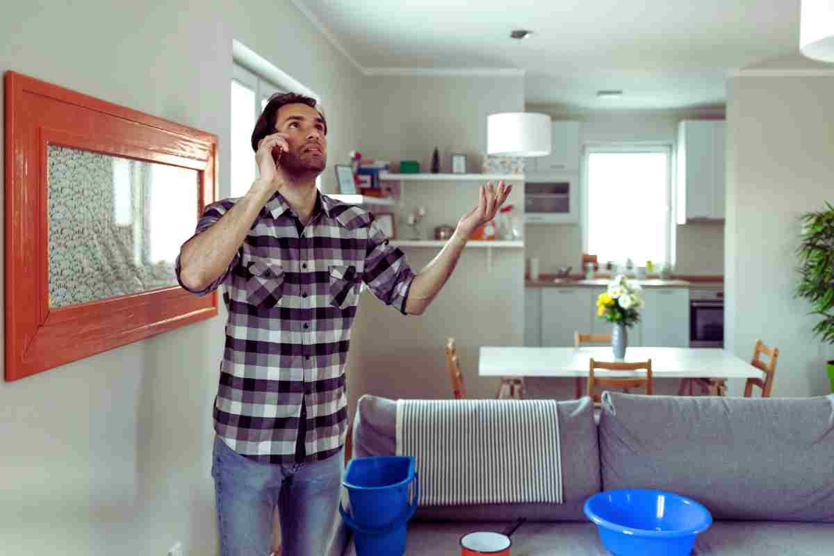 uomo in casa al telefono preoccupato