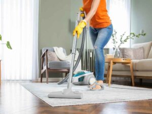 donna che pulisce pavimento con aspirapolvere
