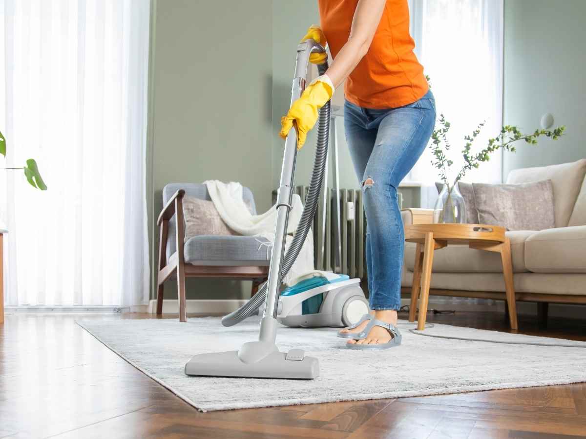 donna che pulisce pavimento con aspirapolvere