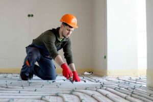 Uomo installa riscaldamento a pavimento