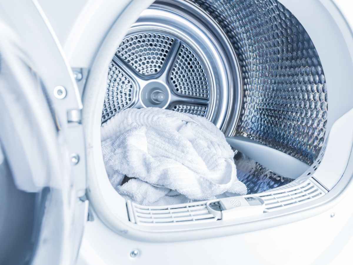 asciugamano bianco dentro il cestello dell'asciugatrice